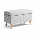 Storage ottoman with soft gray fabric upholstered surface and wooden legs 80 x 40 x 45cm